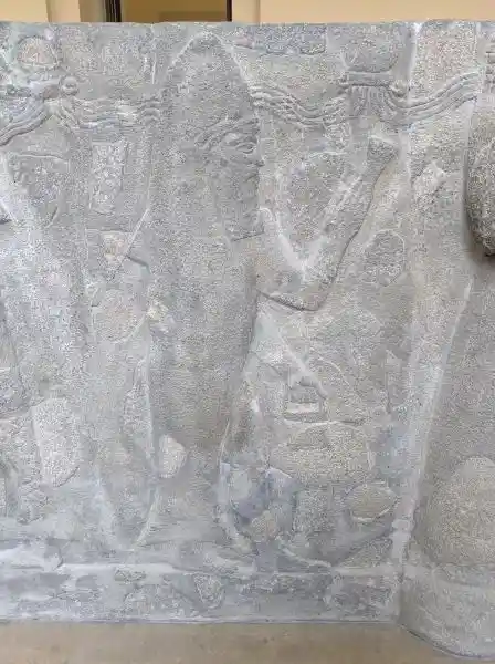 Detail of the reconstruction of basalt water basin, a man in fish clothes (facing right), located in Pergamon museum.